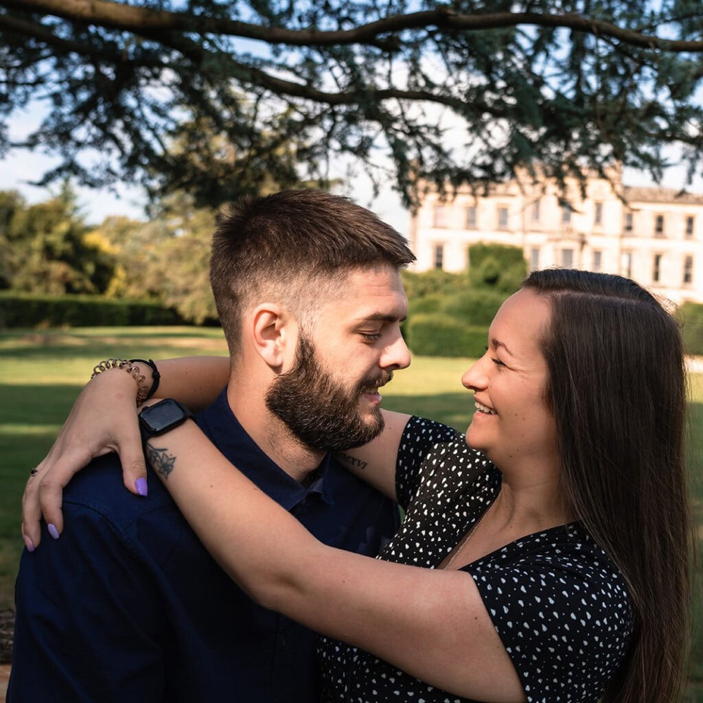 Smiling couple embraces in a sunny garden