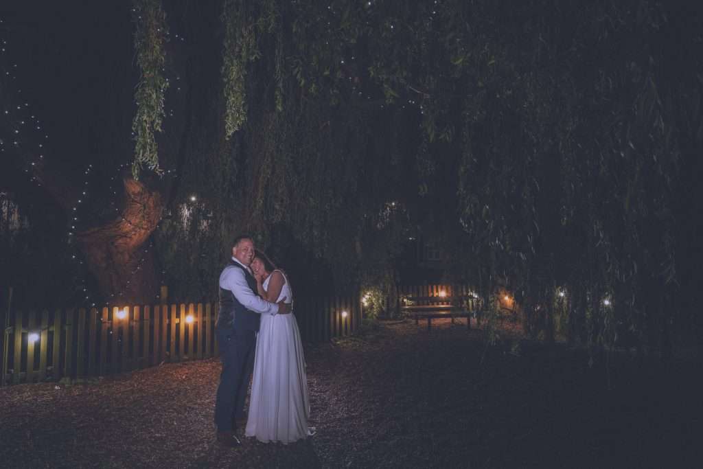 Newly wed couple under a tree lit with fairy lights at the Priest House Hotel