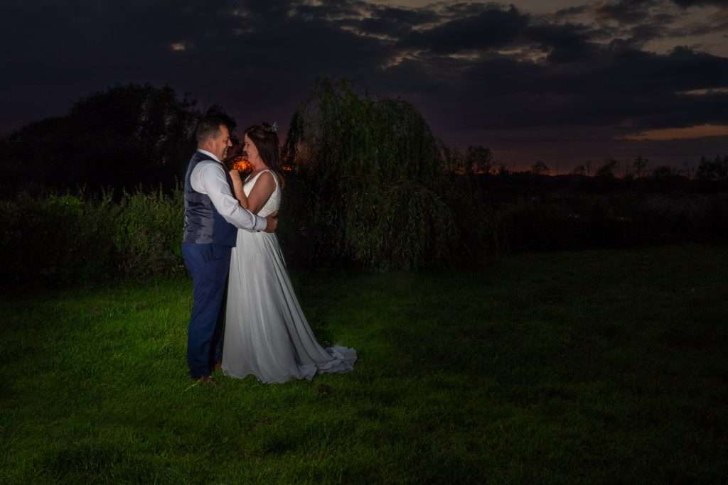 Newly wed couple hugging and looking at each other with a stunning sunset in the background at The Pries House Hotel